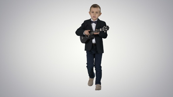 Boy in a costume walking and playing ukulele on gradient alt