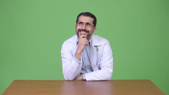 Handsome Persian Bearded Man Doctor Smiling While Thinking