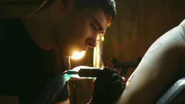 Portrait of Tattooist with Covered in Plastic Film Tool