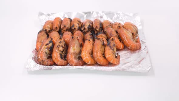 place the grilled river prawns in a row on foil for sell and delivery. alt