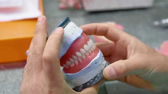 Dental Technician Works in His Workshop and Makes Teeth for Dentistry alt