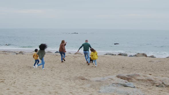 Parents and Kids Walk Their Dog On Ocean Coast