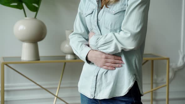 Discontent Female Suffers From Abdominal Stomach Pain Touches Belly with Both Hands alt