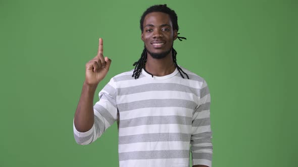 Young Handsome African Man with Dreadlocks Against Green Background alt