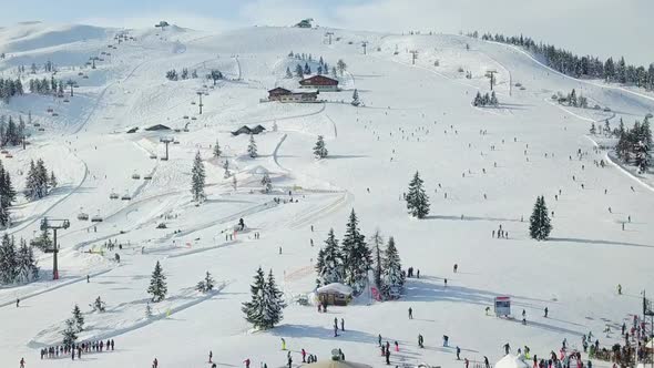Beautiful Drone view of a crowded snow slope on snowy mountain in the French Alps, Flachau, Austria alt