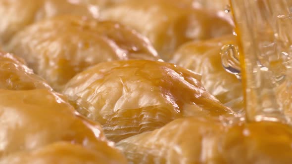 Sherbet pours down onto baklavas in slow motion. (close-up)