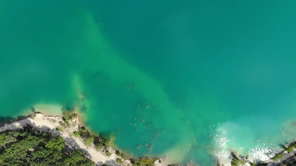 Aerial View of a Blue Lake Surrounded By Forest alt