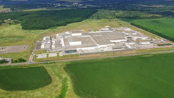 View from above on a modern industrial estate among green trees. alt