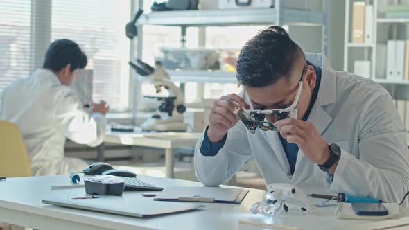 Male Engineer Inspecting Circuit Board in Laboratory alt