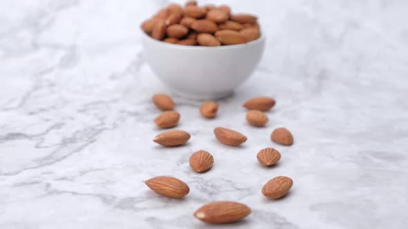 Dolly shot Almonds nuts on marble background.