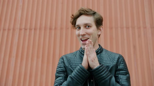 Portrait of Evil Guy Rubbing Hands and Smiling Making Plan Standing Outdoors alt