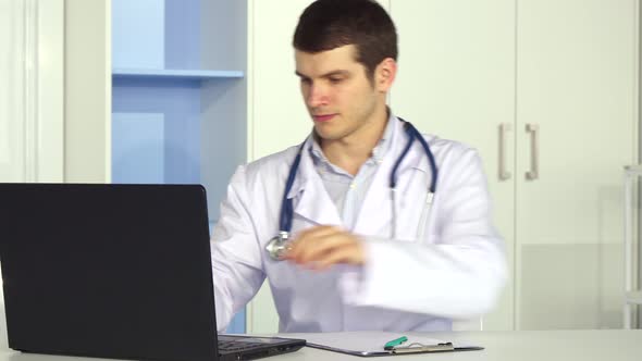 Pediatrician Writes on Clipboard at the Office alt