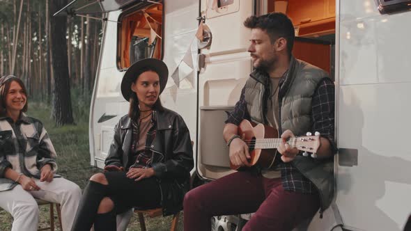 Slowmo of Man Playing Ukulele at Campground alt