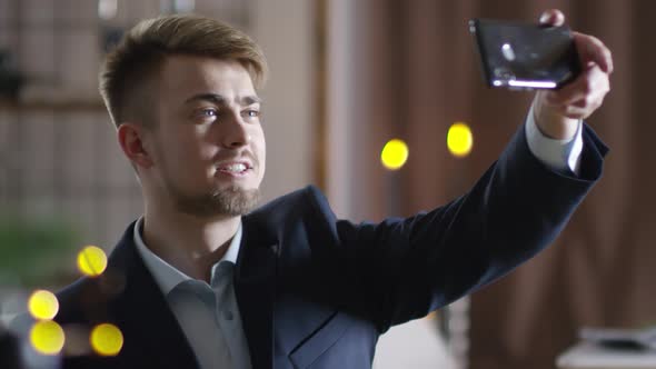 Young Caucasian Man Taking Selfies at Christmas Party alt