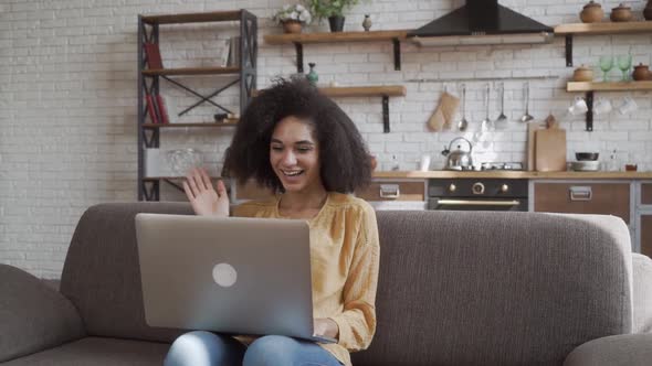 Happy African American Young Woman Looking at Computer Screen, Waving Hello. Pleasant Attractive alt