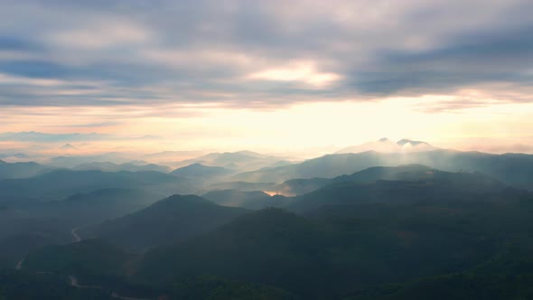 4K Flying through the clouds above mountain tops. Tropical forest with smoke and fog. alt
