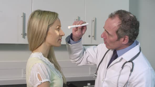 CU Male doctor examining woman's eyes in hospital / London, Greater London, United Kingdom.