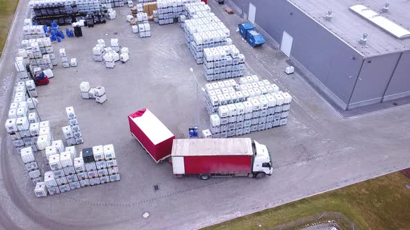 Forklift truckse between large shelves at outside warehouse and load pallets.Aerial. Drone shot alt