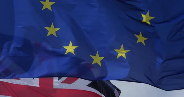 The national UK and European flags waving in the wind. alt