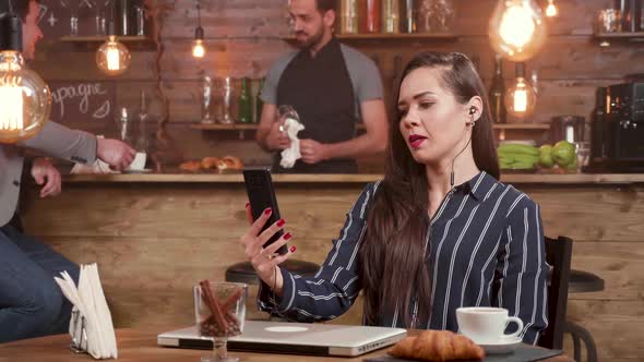Young Businesswoman Engaged in a Video Call in a Coffee Shop alt