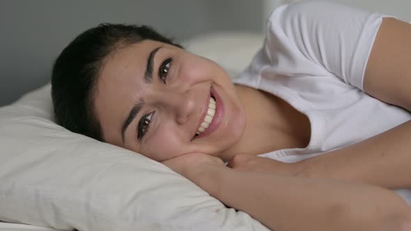 Indian Woman Laying in Bed Smiling at Camera  alt