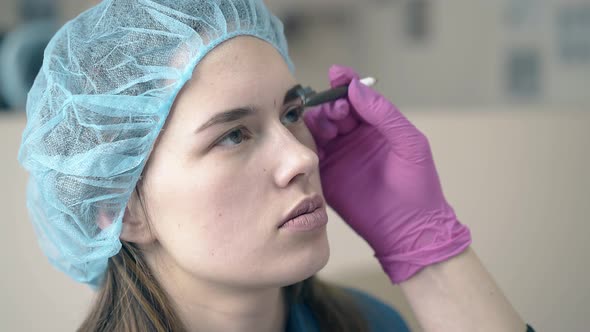 Master Brushes Girl Eyebrow with Fresh Tattooing in Salon alt