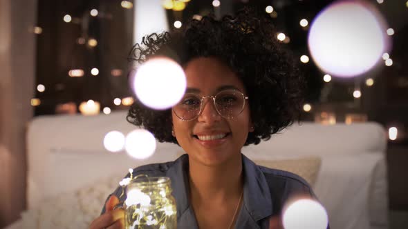 Woman with Garland Lights in Glass Mug at Night