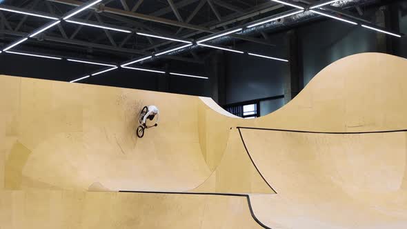 BMX Sports  Young Man Riding on the Springboards on the Indoors Training Ground alt