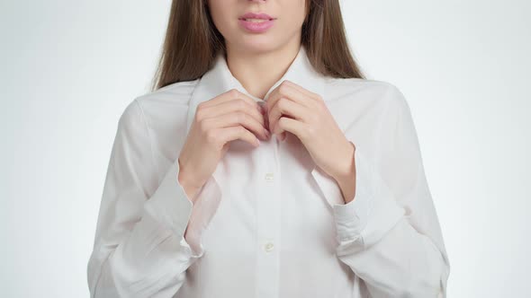 Sexy woman undresses unbuttoning the buttons on a white business shirt. alt