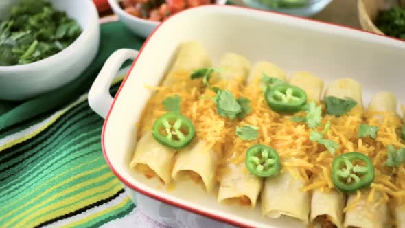 Chicken enchiladas with cheddar cheese and sauce. alt