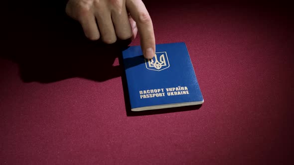  Showing and pointing gesture to Ukrainian Travel document Passport for travel abroad  