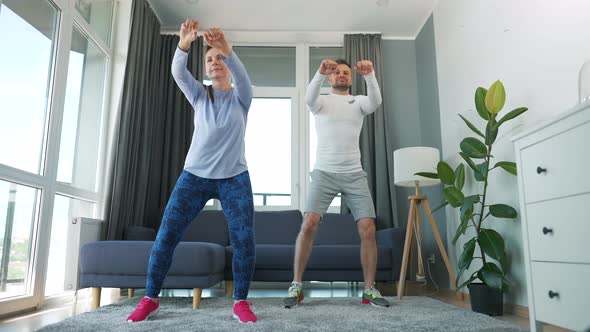Caucasian Couple is Doing Cardio Exercise at Home in Cozy Bright Room Slow Motion alt
