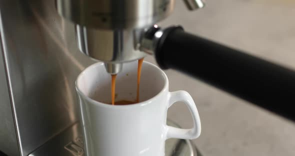 Making Coffee By Coffee Machine Into Cup Espresso Coffee Coming Out From an Coffemaker Machine