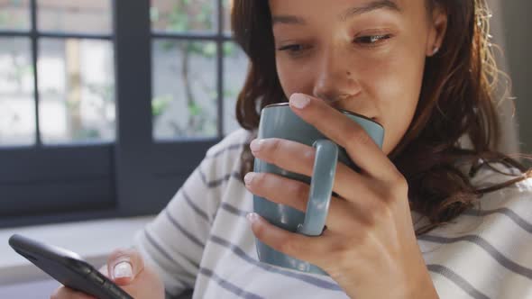 Mixed race woman enjoying drinking tea. Social distancing and self isolation in quarantine alt