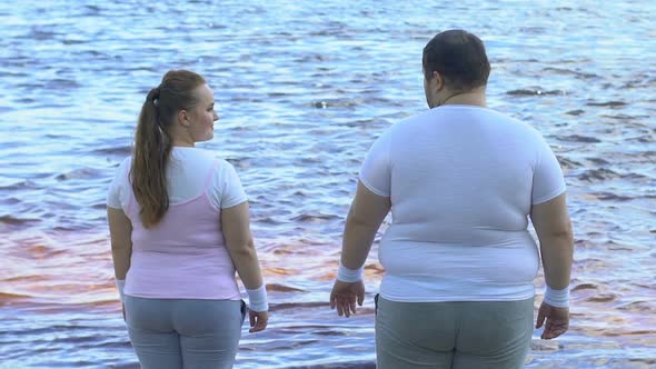 Obese Man Taking Girlfriends Hand, Couple Enjoying Beautiful View of River alt