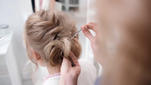 Professional Woman Stylist Final Touch of Hairstyling Use Bobby Pin alt