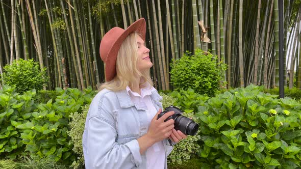 Photographer Takes a Pictures on a Camera in the Garden