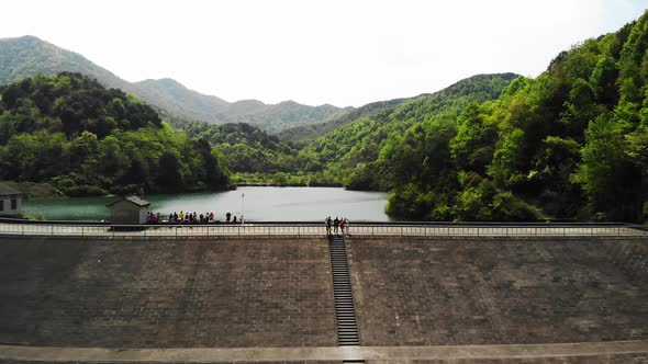 Aerial View a Dam with Green Mountains and Some People