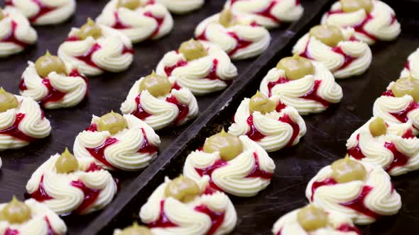 Cakes with Strawberry and Orange Jam on the Conveyor of a Confectionery Factory alt
