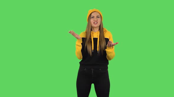 Modern Girl in Yellow Hat Is Reporting and Telling a Lot of Interesting Information. Green Screen alt