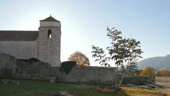 A bell tower close to stone ruins  alt