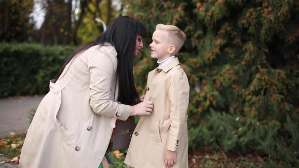 Mom and Son are Walking in the Park in Autumn