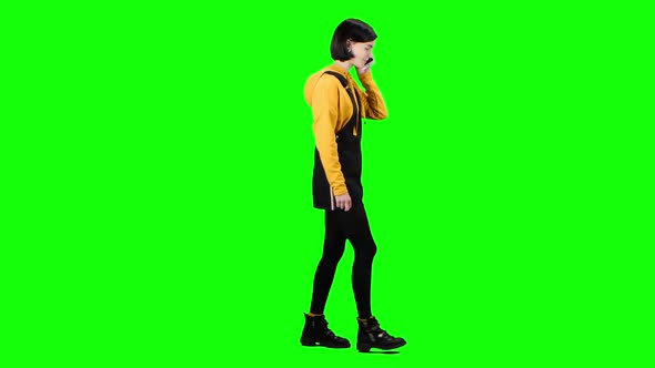 Girl Is Talking on the Phone Walking Down the Street. Green Screen. Side View alt