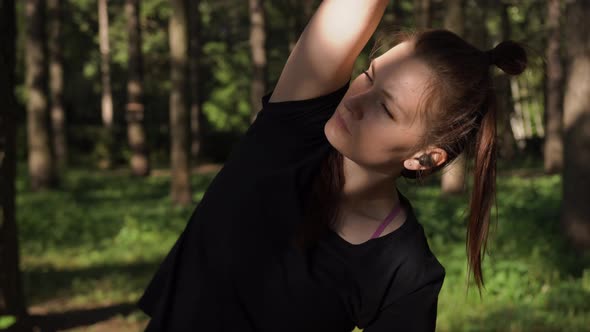 Woman Warms Up Before Training Early in the Morning at Dawn in the Forest Park alt