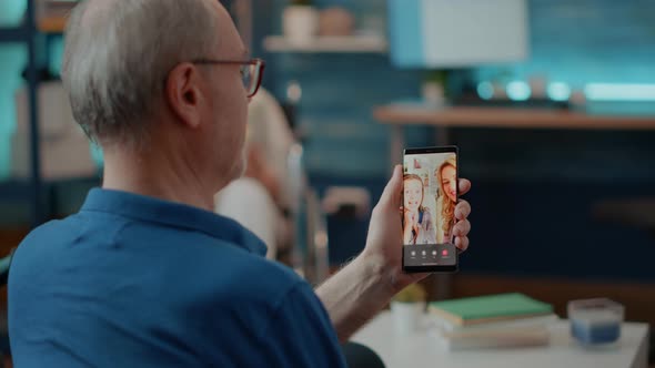 Retired Man Talking to Family on Online Videoconference alt