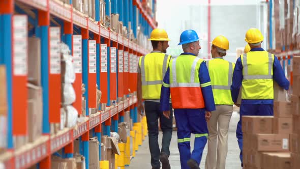 Male and female warehouse worker carrying cardboard boxes alt