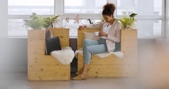 Businesswoman sitting on sustainable wood sofa for coffee alt