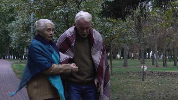 Caring Wife Helping and Supporting Her Old Husband With Walking Stick, Family