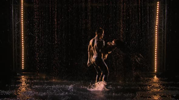 Passionate Couple in Love Kiss and Caress Each Other in Pouring Rain in Dark Studio alt