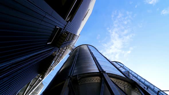 Storage tanks. Grain elevator on blue sky background alt